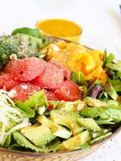 a salad with broccoli, tomatoes and other vegetables in a bowl on a table