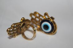 "Gorgeously beautiful, unique and one of a kind large Hamsa evil eye adjustable ring in antique gold or Tibetan silver. Size over 1 1/2\". Since the Hamsa is considered a gift of love it makes it the perfect gift. For those of you who are not familiar with the Hamsa, well, it's a symbol that's been around for thousands of years and is believed to protect and shield against the evil eye, generate positive energy, provide good fortune, health, prosperity and happiness. CUSTOM ORDERS WELCOME DELIVE Evil Eye Ring Jewelry Gift, Spiritual Evil Eye Ring Jewelry, Symbolic Evil Eye Jewelry Ring, Symbolic Evil Eye Ring Jewelry, Adjustable Evil Eye Ring Jewelry, Adjustable Evil Eye Open Ring Jewelry, Adjustable Open Ring With Evil Eye, Adjustable Open Ring With Evil Eye Detail, Evil Eye Open Ring As Gift