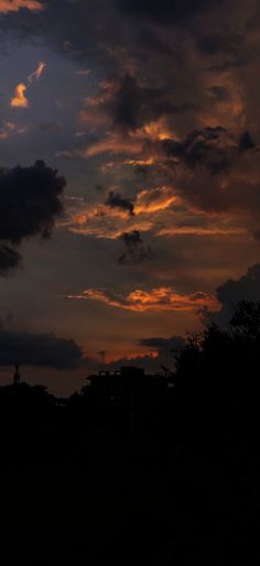 the sun is setting behind some clouds in the sky