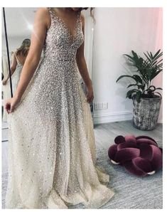 a woman standing in front of a mirror wearing a dress with sequins on it