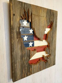 a wooden wall hanging with an eagle and stars painted on the wood, in red white and blue colors