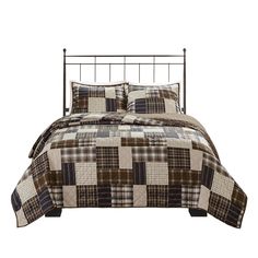 a bed with a brown and white plaid comforter set on it's side