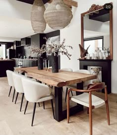 a dining room table with chairs and vases on top of it in front of a mirror