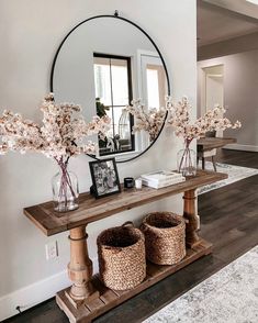 there is a mirror and some flowers on the table in this room with two baskets