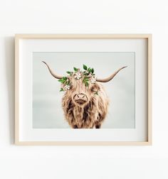 an animal with long horns and flowers in it's hair is mounted on the wall