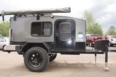 an off - road camper is parked in a parking lot