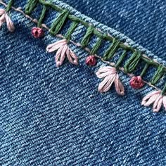 the stitching is being worked on by someone who has sewn flowers in them