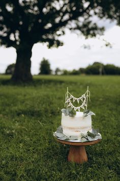 a cake sitting on top of a wooden stand in the grass