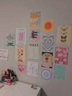 a white desk topped with lots of art on the wall next to a dryer