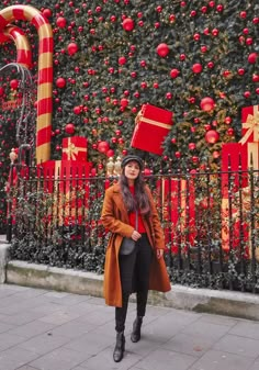 a woman standing in front of a christmas tree with presents on it's head