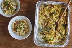 two bowls of pasta with chicken and broccoli in them on a wooden table