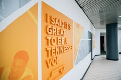 there is a large orange sign on the wall in an office building that says i salute great to be a tennessee vol