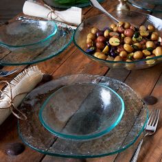 three glass bowls filled with different types of food on top of a wooden table next to silverware