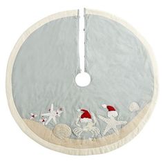 a white christmas tree skirt with horses and santa's hats hanging from the top