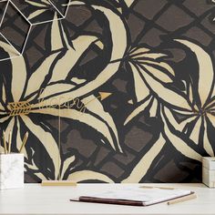 an artistic wallpaper design with gold and black flowers on the side, next to a book