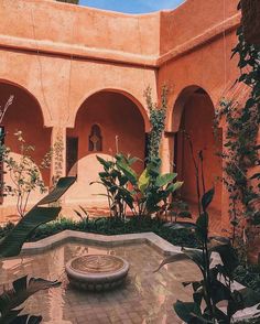 a courtyard with a fountain surrounded by greenery