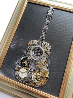 "Guitar model M 641 Guitar model artwork is a stunning masterpiece made from antique clock and watch parts, metallic accessories, and clock mechanisms. Its functional clock also makes it an ideal gift for collectors who appreciate the intricate beauty of timepieces. The artwork is presented in a stylish frame with dimensions of W 29 cm x H 38 cm (11,41\" x 14,96\" inches). The artwork will be packaged with bubble wrap in a cardboard box to ensure it arrives safely. Please ensure you include your phone number in the 'comments' section of your order for courier contact.  Wish to receive new items and updates through your Etsy home page? Please 'favorite' my shop!  www.etsy.com/shop/TransylvaniaClockArt * Keep in mind that the colors of my artwork might appear a little different on the actual Steampunk Art Wall Clocks, Making Art From Vintage Watches, Making Art Using Watches, Watch Artwork, Making Art Using Vintage Watches, Steampunk Guitar Art, Dark Steampunk Art, Watch Art, Steam Punk Art