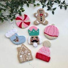 six knitted christmas ornaments are arranged on a table next to a pot holder and plant