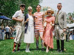 a group of people standing next to each other on top of a lush green field