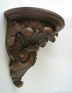 an ornate wooden shelf mounted on the wall