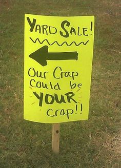 a yellow yard sale sign with an arrow pointing to the right and another handwritten message on it