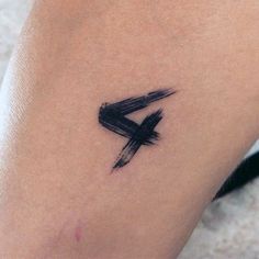 a small black arrow tattoo on the leg