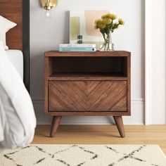 a bedroom with a bed, nightstand and pictures on the wall above it is shown