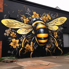 a painting of a bee on the side of a building with flowers painted on it