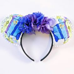 a close up of a headband with flowers on it and a purple flower in the middle