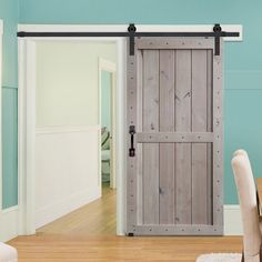 an open wooden door in a room with blue walls and wood flooring on the side