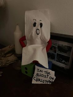 a toilet paper bag sitting on top of a table next to a sign that says i'm the ghost of christmas