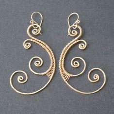 two pairs of earrings with spiral designs on them, one is gold and the other is silver