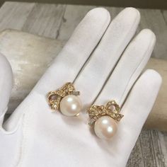 "This elegant pair of pearl earrings are marked by French Designer Nina RICCI. The earrings feature a pearl with a gold plated bow resting on top. Numerous Swarovski crystals are set in the bows. One emerald clear cut stone is placed on each earring. The earrings are clip on and Nina RICCI 's name is marked on the back of the clips. The earrings were made in France. In 1984, D'Orlan Jewelers Ltd. of Toronto, Canada formed a partnership with the Nina Ricci Enterprises of Paris, France (known thro French Designs, French Luxury, French Designer, Jewelry Bridal, Fashion Industry, Luxury Goods, Toronto Canada, French Design, Designer Jewelry