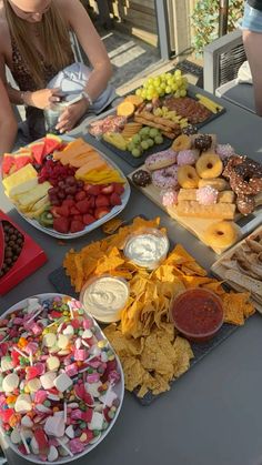 a table topped with lots of different types of snacks and desserts on trays