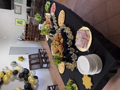 a buffet table set up with food and balloons