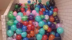 there is a bunch of balloons in the bins on the floor next to each other