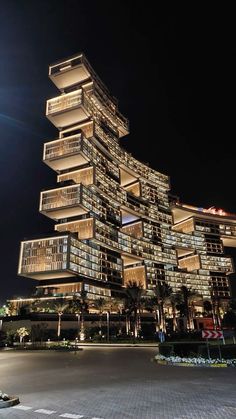 a very tall building with lots of balconies on it's sides at night