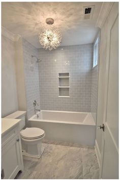 the bathroom is white and has gray tile on the walls, floor, and ceiling