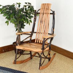 a wooden rocking chair next to a potted plant