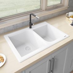 two white sinks sitting on top of a counter next to a bowl of green apples