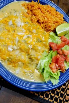 a blue plate topped with rice, meat and veggie covered enchilada