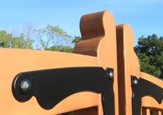 a close up view of a wooden playground structure with black handles and latches on it