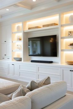 a living room filled with furniture and a flat screen tv mounted on a wall above it