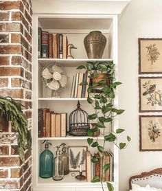 a bookshelf filled with lots of books next to a wall mounted clock and potted plant