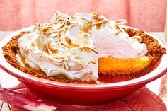 a pie with whipped cream on top in a red bowl