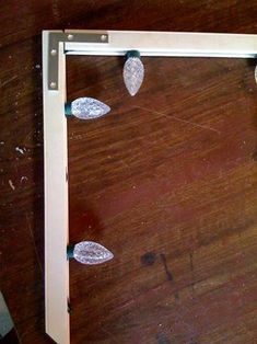 a wooden table topped with lots of metal objects on it's sides and a white frame