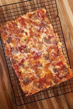 a square pizza sitting on top of a metal rack