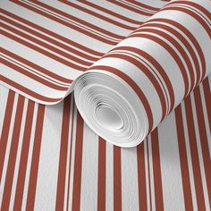 a red and white striped wallpaper with stripes on the bottom, along with a roll of paper