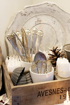 an old wooden box filled with silverware and other kitchen utensils on top of a table