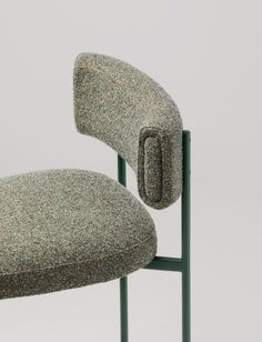 an upholstered chair with a green metal frame and seat cushion on the back